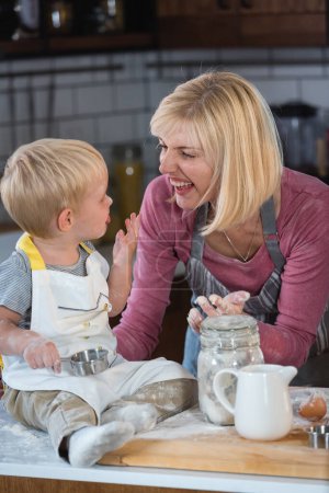 Foto de Madre pasar tiempo de calidad con un niño en la cocina, hornear un pastel - Imagen libre de derechos