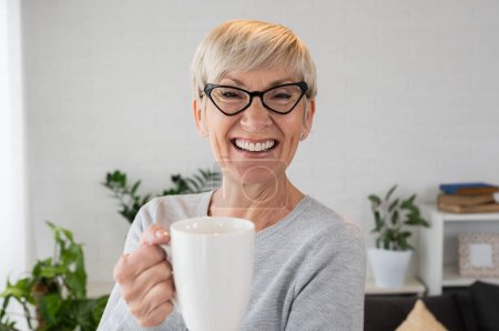 Photo for Environmental indoors high key portrait of an elderly woman with eyeglasses - Royalty Free Image