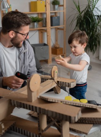 Foto de Padre haciendo plano de madera para su hijo - Imagen libre de derechos