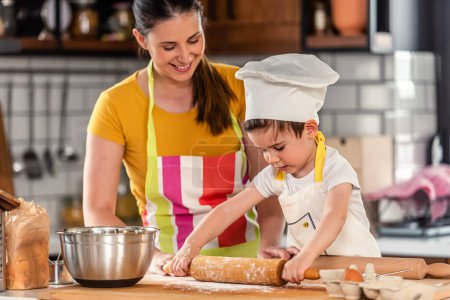 Photo for Mother cooking with son. working with dough - Royalty Free Image