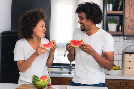 Téléchargez les photos : Couple afro-américain manger pastèque - en image libre de droit