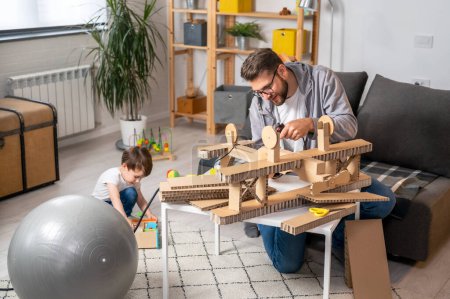 Photo for Father and son making wooden plane - Royalty Free Image