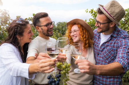 Téléchargez les photos : Amis heureux de boire du vin au vignoble - en image libre de droit