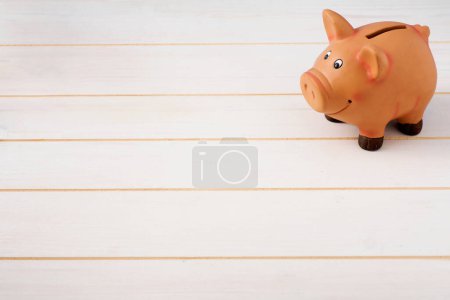 Photo for Piggy bank with wooden background - Royalty Free Image