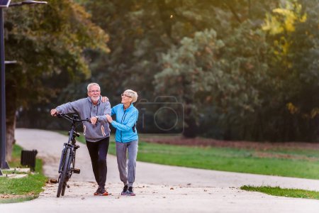 Foto de Pareja mayor con bicicleta en el parque - Imagen libre de derechos