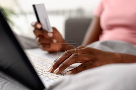Foto de Mujer afroamericana usando laptop, sosteniendo tarjeta de crédito - Imagen libre de derechos