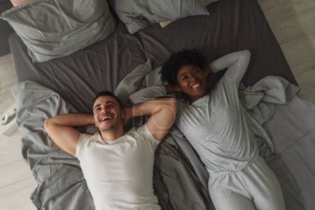 Téléchargez les photos : Jeune couple amoureux couché sur le lit - en image libre de droit