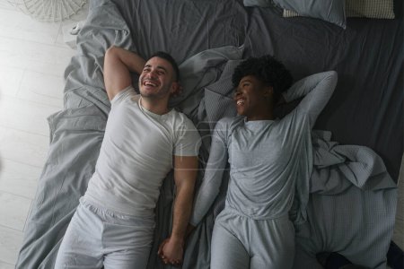 Photo for Young couple in love lying on bed - Royalty Free Image