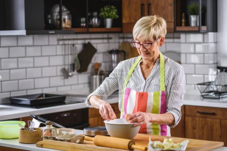 Photo for Beautiful senior woman making dough for cookies - Royalty Free Image