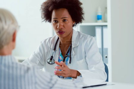 african american doctor examining senior woman patient