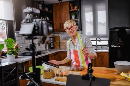 Photo for Senior woman food blogger filming recipe - Royalty Free Image