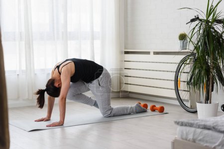 Foto de Mujer joven practicando yoga en casa. Rutinas deportivas diarias para un estilo de vida saludable y alivio del estrés. - Imagen libre de derechos