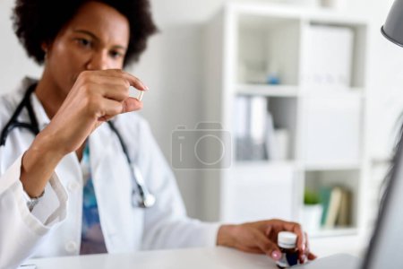 Téléchargez les photos : Travailleur médical stressé travaillant à son bureau prenant la pilule - en image libre de droit