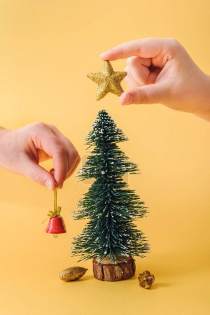 Foto de Pequeño árbol de Navidad decoración en las manos - Imagen libre de derechos
