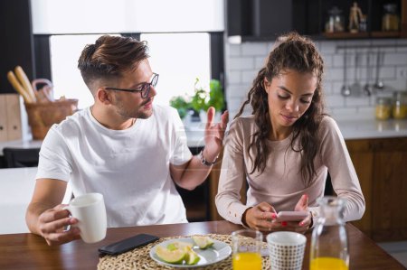 Téléchargez les photos : Jeune couple à la cuisine de la maison le matin ayant des problèmes relationnels. Arguments. - en image libre de droit