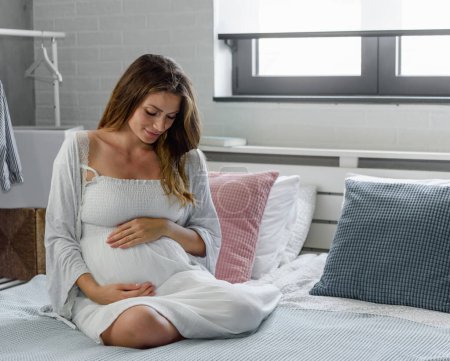 Téléchargez les photos : Femme enceinte au lit - en image libre de droit