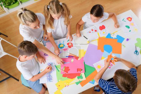 Photo for Kids making handicrafts with teacher at school - Royalty Free Image