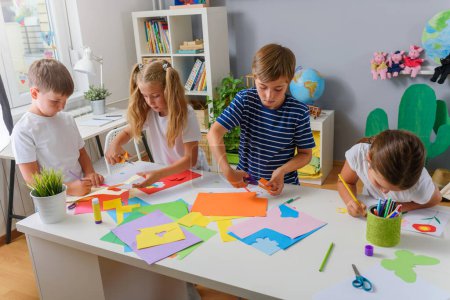 Foto de Niños haciendo artesanías de papel en el jardín de infantes - Imagen libre de derechos