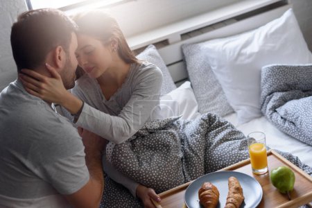 Photo for Modern young love couple at home showing affection with breakfast - Royalty Free Image