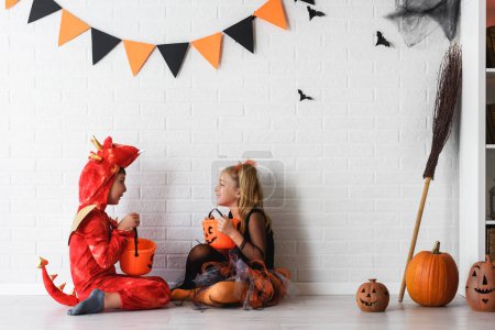 Téléchargez les photos : Concept d'Halloween. heureux petite fille et garçon en costumes - en image libre de droit