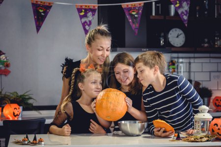 Photo for Happy children with mother carving carving jack o lantern - Royalty Free Image
