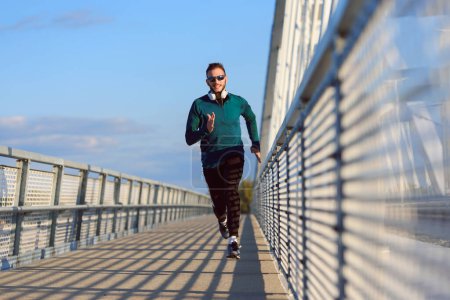 Foto de Joven fitness hombre en forma corriendo en una calle de la ciudad. estilo de vida saludable - Imagen libre de derechos