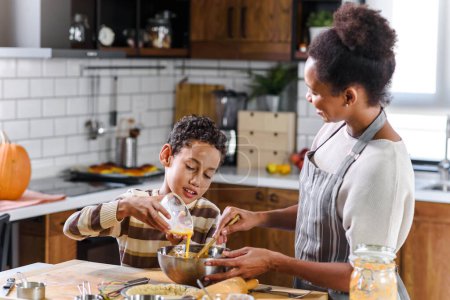 Téléchargez les photos : Afro-américaine mère et fils préparant tarte à la citrouille - en image libre de droit