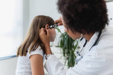 Photo for African american doctor examining little girl - Royalty Free Image