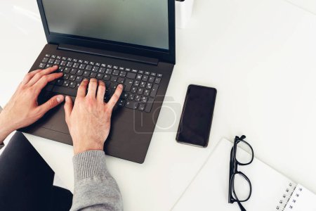 Foto de Vista del hombre de negocios utilizando el ordenador portátil, escribiendo en la oficina - Imagen libre de derechos
