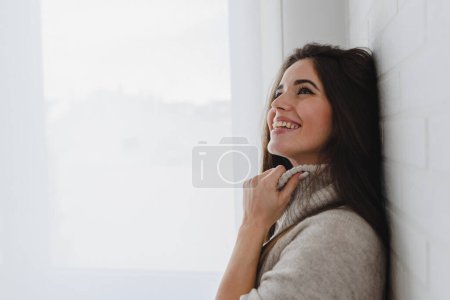 Foto de Joven hermosa embarazada posando cerca de ventana - Imagen libre de derechos