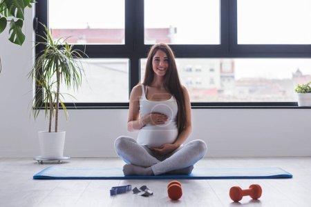 Foto de Mujer embarazada haciendo ejercicio en el gimnasio - Imagen libre de derechos