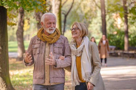 Photo for Senior couple walking in autumn park - Royalty Free Image