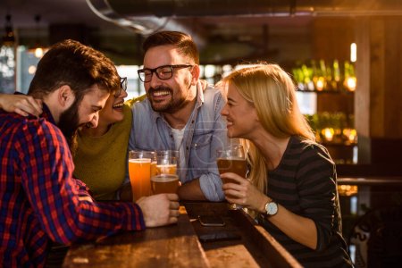 Foto de Grupo de jóvenes amigos en el bar bebiendo cerveza - Imagen libre de derechos