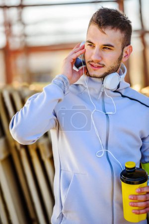 Foto de Corredor de hombre guapo urbano con auriculares y teléfono - Imagen libre de derechos