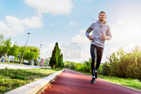 Téléchargez les photos : Homme jogging le matin sur la piste de course - en image libre de droit