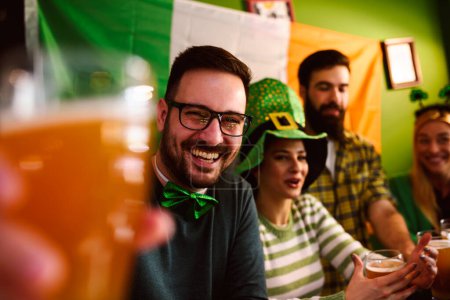 Photo for Group of Friends Celebrating St Patrick's Day in Beer Pub - Royalty Free Image