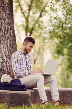 Photo for Young businessman with laptop working in the park - Royalty Free Image