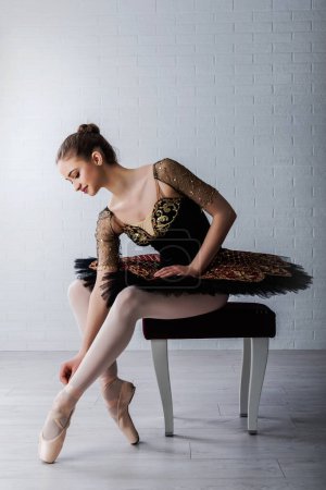 Téléchargez les photos : Portrait de Jeune Belle ballerine parfaite assise sur une chaise à l'intérieur - en image libre de droit