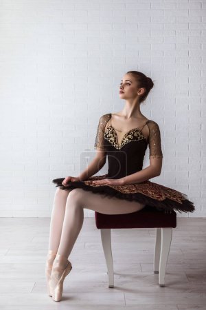 Téléchargez les photos : Portrait de Jeune Belle ballerine parfaite assise sur une chaise à l'intérieur - en image libre de droit