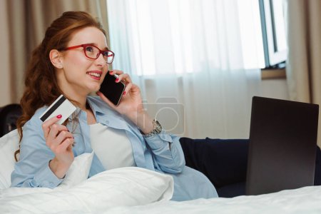 Photo for Young beautiful woman with credit card making order in online store - Royalty Free Image