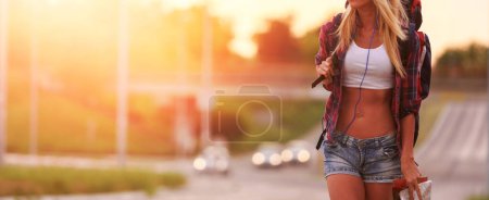 Téléchargez les photos : Jeune belle femme blonde en jeans shorts au coucher du soleil dans la ville - en image libre de droit