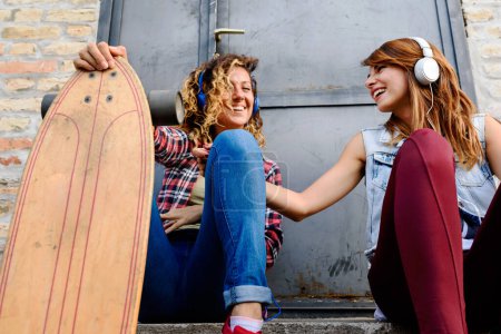 Foto de Dos niñas patinadores pasar tiempo juntos al aire libre - Imagen libre de derechos