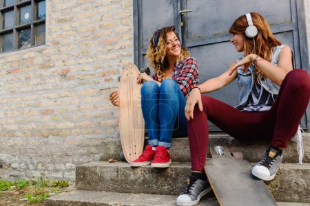 Photo for Two girls skaters spending time together outdoors - Royalty Free Image