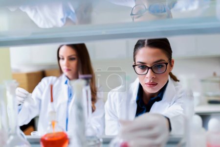 young female scientists working in laboratory  tote bag #653507830