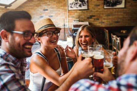 Téléchargez les photos : Amis boire de la bière dans un pub - en image libre de droit