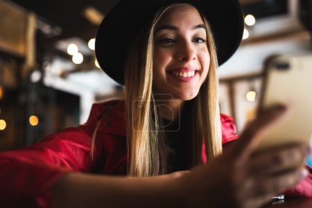 Photo for Young woman with mobile phone in cafe - Royalty Free Image