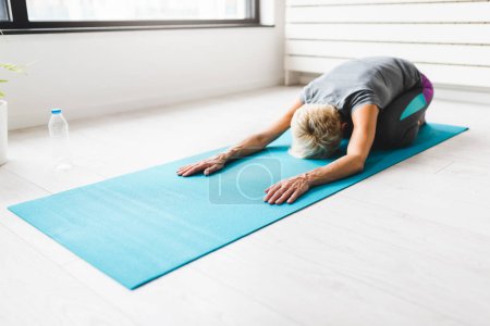 Foto de Mujer mayor haciendo ejercicios de yoga - Imagen libre de derechos