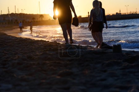 Téléchargez les photos : Jeune couple au coucher du soleil sur la plage - en image libre de droit