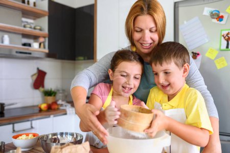 Foto de Madre, hija e hijo cocinando pastelería juntos, trabajando con masa - Imagen libre de derechos