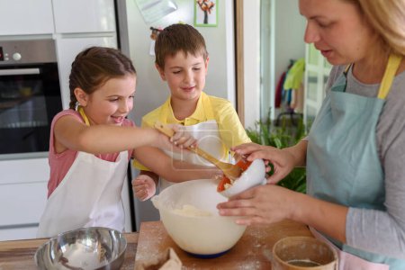 Foto de Madre, hija e hijo cocinando pastelería juntos, trabajando con masa - Imagen libre de derechos